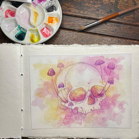 Watercolor painting of a female skull intertwined with delicate purple mushrooms, capturing the intricate blend of natural beauty and mortality by J. Brooke Wade.